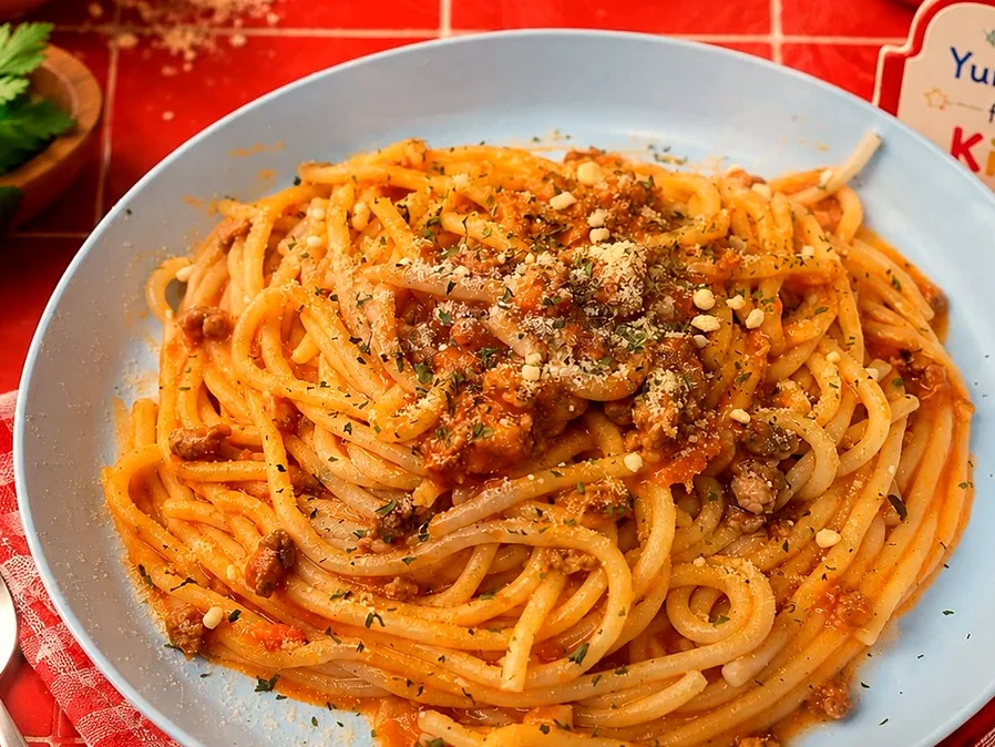 Kids spaghetti with tomato meat sauce, parmesan and fresh herbs
